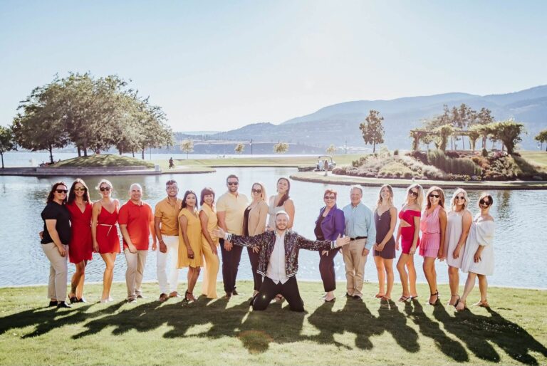 Group of people in front of water in colourful, rainbow clothing